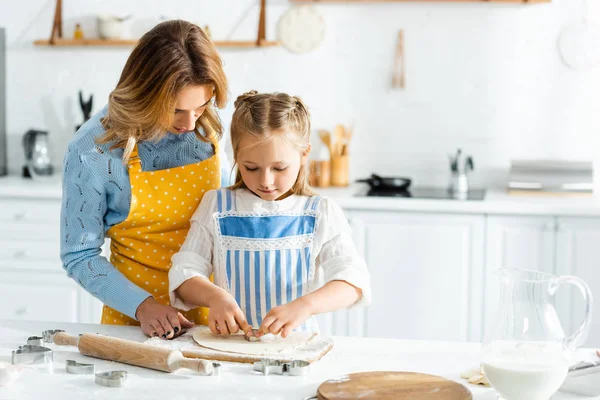 Mother and daughter cooking with dough mold in kitchen — Stock Photo
