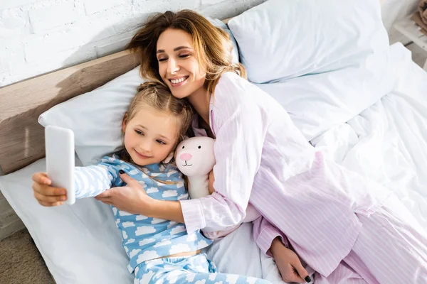 Visão de alto ângulo da filha tomando selfie com mãe sorridente — Fotografia de Stock