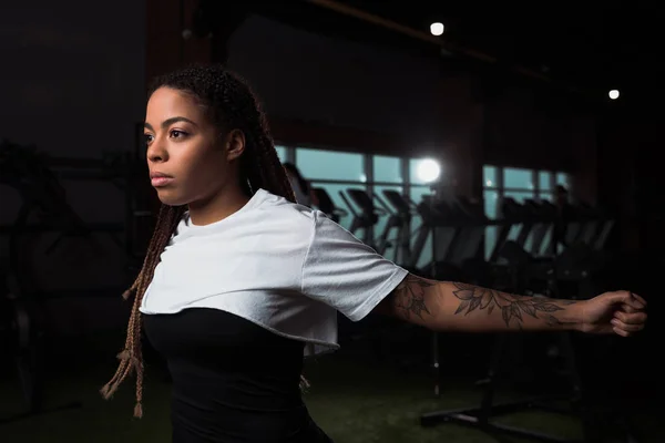 Afroamerikanerin dehnt sich vor dem Training im Fitnessstudio — Stockfoto