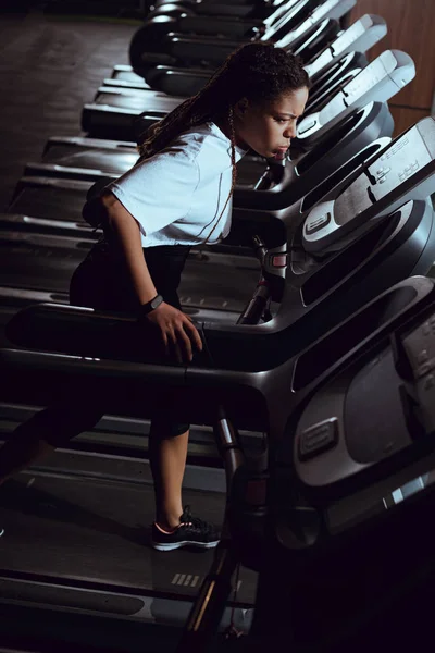 High angle view of african american woman running on treadmill in gym — Stock Photo