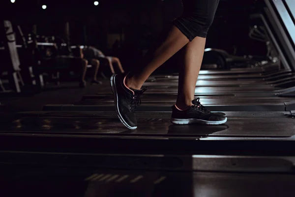 Vista ritagliata della donna afroamericana che indossa scarpe da ginnastica sul tapis roulant — Foto stock