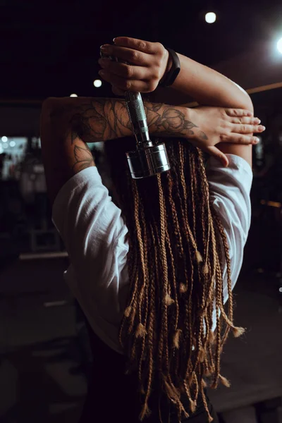 Vue arrière de femme afro-américaine main tenant haltère — Photo de stock
