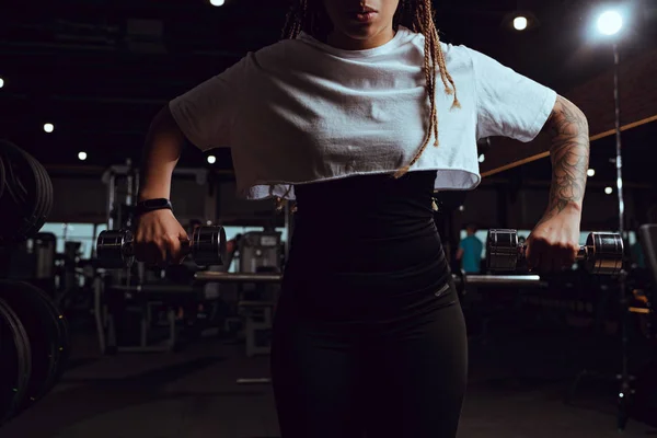 Cropped view of african american woman holding dumbbells — Stock Photo