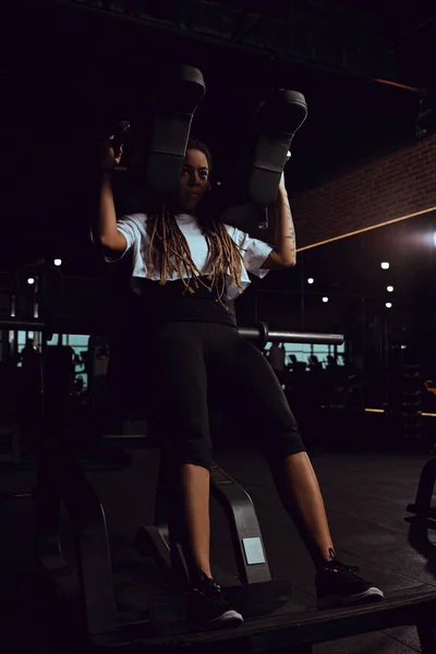 Mujer afroamericana haciendo ejercicio en la máquina de gimnasio - foto de stock