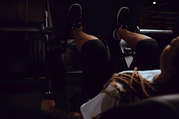 Selective focus of tattooed african american girl working out on fitness machine — Stock Photo