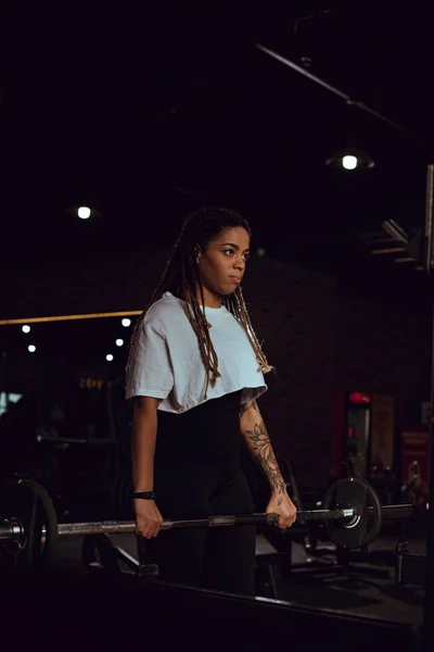 Atlético afro-americano mulher exercitando com barbell no ginásio — Fotografia de Stock