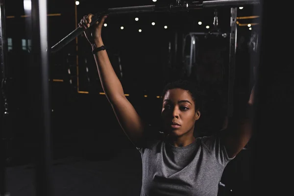 Selective focus of african american girl training on gym machine — Stock Photo