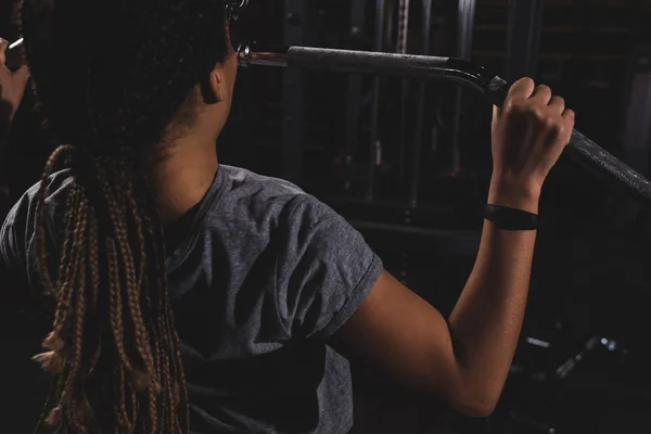 Vue arrière de jeune fille afro-américaine avec formation smartwatch dans la salle de gym — Photo de stock