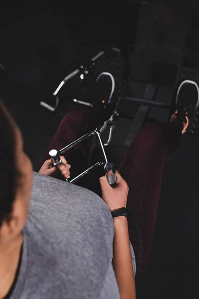 Vue aérienne d'une sportive américaine africaine athlétique avec une montre intelligente faisant de l'exercice dans une salle de gym — Photo de stock
