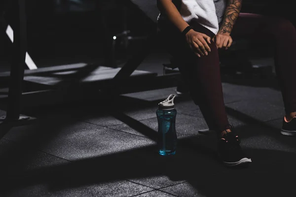 Abgeschnittene Ansicht einer tätowierten Afroamerikanerin, die im Fitnessstudio Knie berührt — Stockfoto