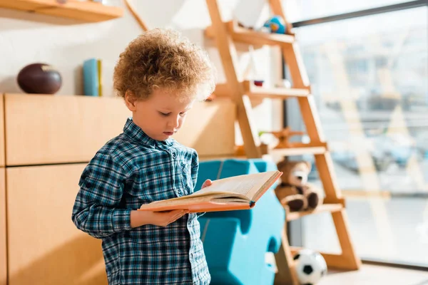 Libro di lettura bambino riccio e intelligente a casa — Foto stock