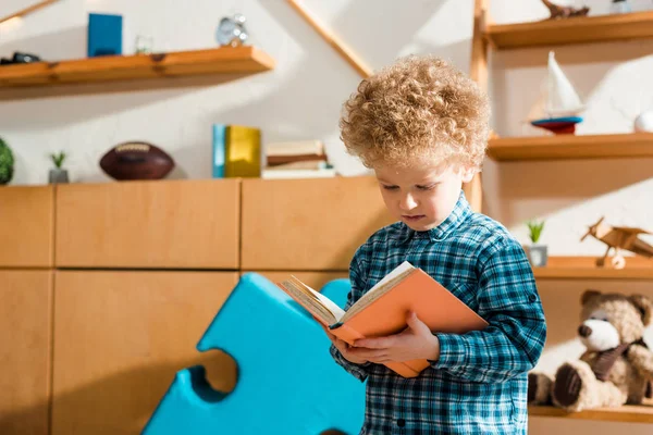 Adorable and smart child reading book at home — Stock Photo