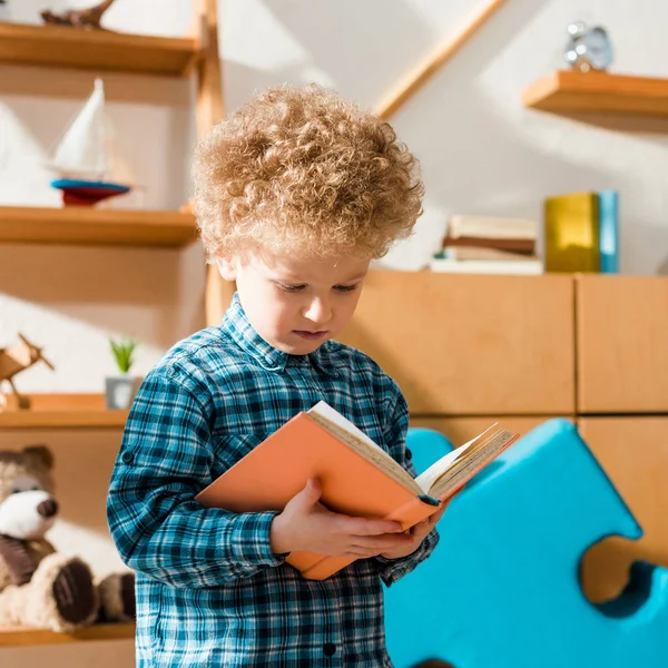 Adorable and smart child reading book at home — Stock Photo