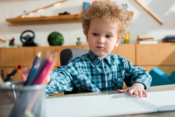 Selective focus of cute boy near blank papers on table — Stock Photo