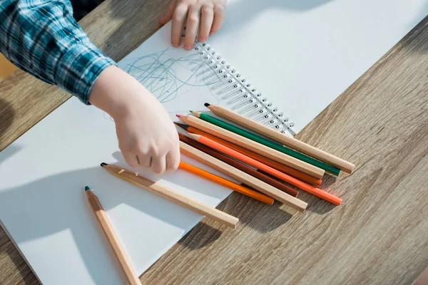 Vue du dessus de l'enfant prenant crayon orange — Photo de stock