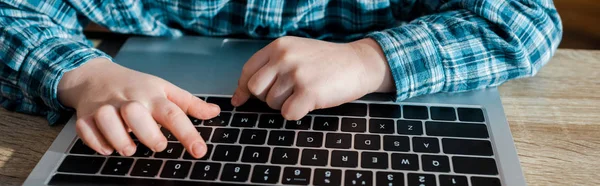 Tiro panorâmico de menino bonito digitando no teclado do laptop — Fotografia de Stock