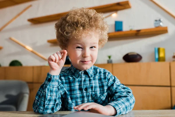 Heureux et bouclé enfant geste tout en regardant la caméra — Photo de stock