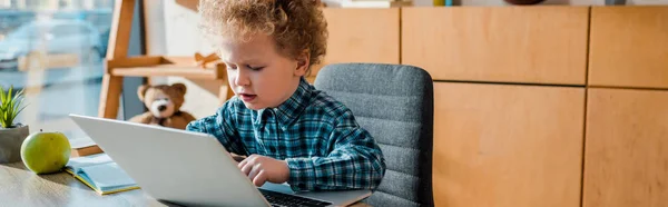 Plan panoramique de mignon enfant en utilisant un ordinateur portable à la maison — Photo de stock