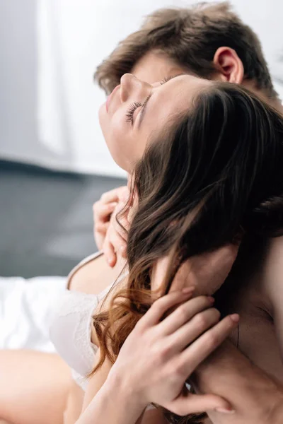 Boyfriend hugging sexy girlfriend in white bra with closed eyes — Stock Photo