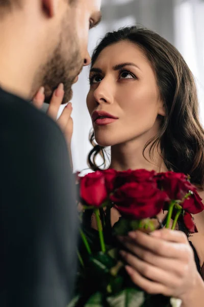 Selective focus of attractive girlfriend with bouquet looking at boyfriend in 14 february — Stock Photo