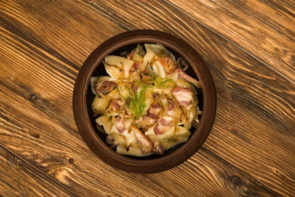 Top view of delicious varenyky with cracklings in bowl on wooden table — Stock Photo