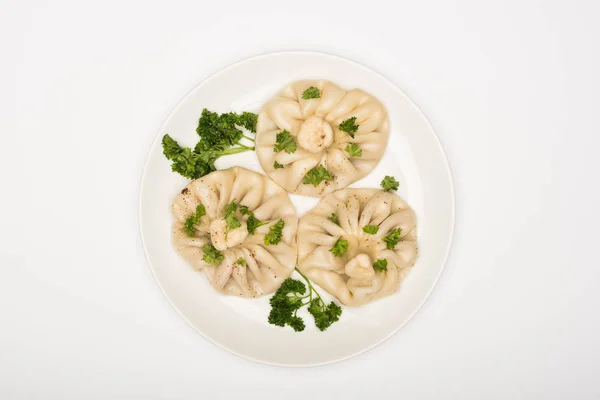 Top view of delicious Khinkali with cilantro on plate on white background — Stock Photo