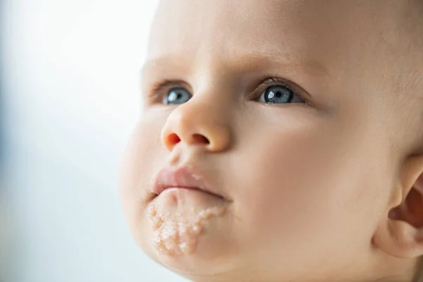 Портрет милого младенца с испачканным ртом и детским питанием, изолированным на сером — стоковое фото