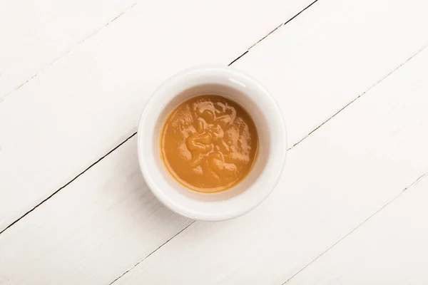 Vista superior da tigela com comida de bebê de couve-flor preparada em fundo de madeira branca — Fotografia de Stock