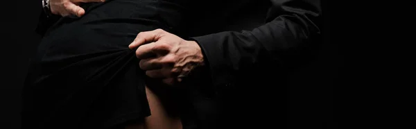 Colpo panoramico di uomo toccando vestito di donna isolato su nero — Foto stock