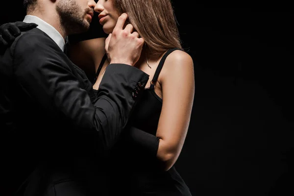 Cropped view of man touching face of woman in dress isolated on black — Stock Photo