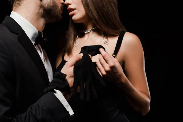 Cropped view of man holding glove near hot woman isolated on black — Stock Photo