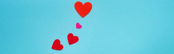Vista superior corazones de papel rojo de aislado en azul, plano panorámico - foto de stock