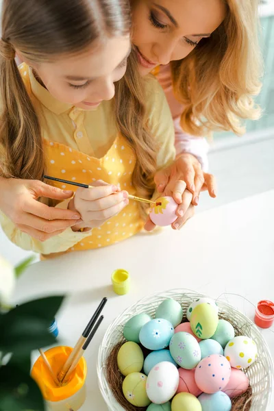 Vista aérea del niño pintando huevo de Pascua cerca de la madre - foto de stock