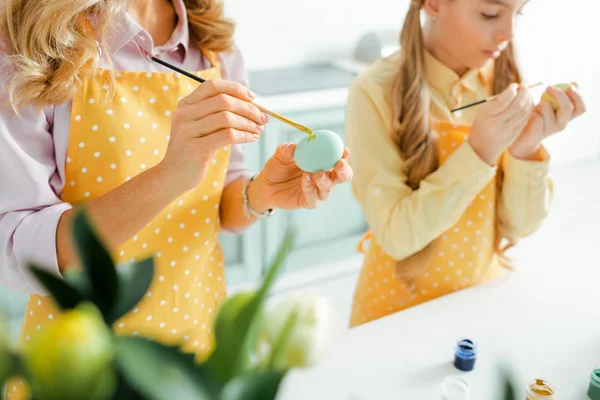 Selective focus of daughter and mother painting easter eggs — Stock Photo