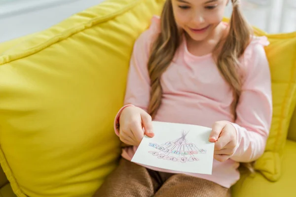 Избирательный фокус жизнерадостного ребенка, смотрящего на поздравительную открытку с надписью 