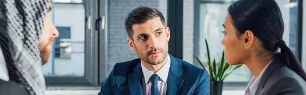 Panoramic shot of multiethnic business partners on meeting with translator in office — Stock Photo