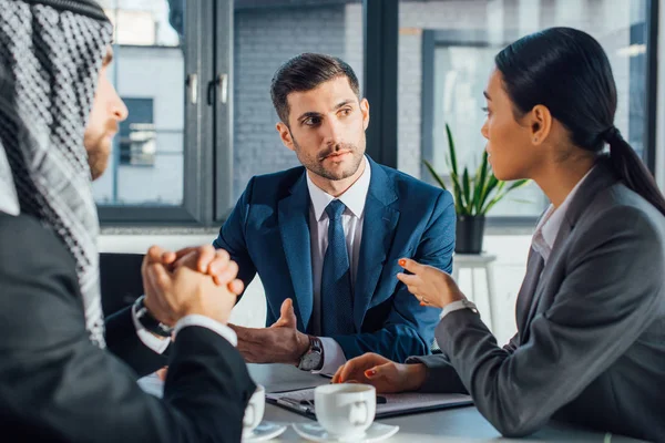 Multicultural business partners talking on meeting with translator in office — Stock Photo