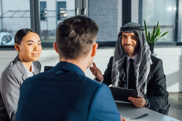 Parceiros comerciais multiculturais felizes discutindo contrato em reunião com tradutor no escritório — Fotografia de Stock