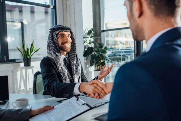 Allegri partner commerciali multiculturali che si stringono la mano e hanno un accordo in ufficio — Foto stock