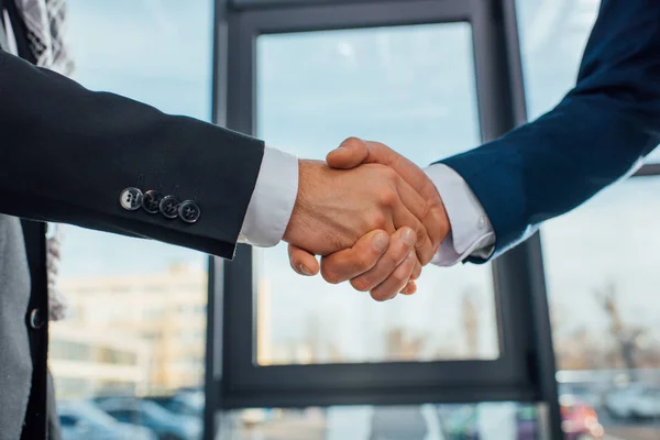 Vue recadrée d'hommes d'affaires serrant la main lors d'une réunion au bureau — Photo de stock
