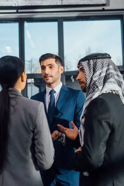 Socios comerciales multiculturales que discuten el contrato de reunión con el traductor en la oficina - foto de stock