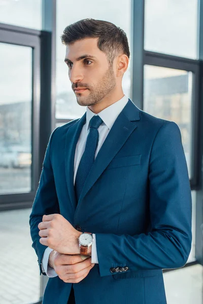 Hombre de negocios profesional en traje de pie en la oficina moderna - foto de stock