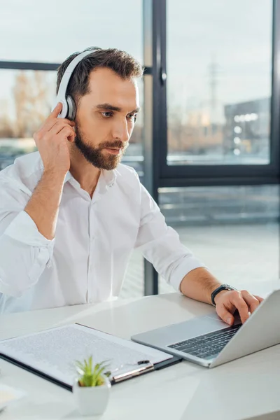 Professional translator working online with headphones and laptop — Stock Photo