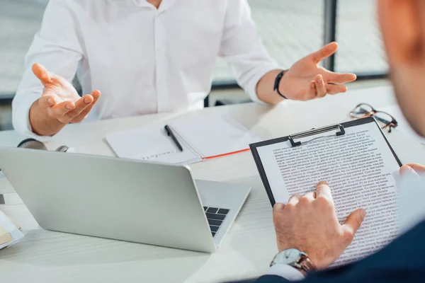 Vue recadrée du traducteur travaillant avec un homme d'affaires et des documents au bureau — Photo de stock