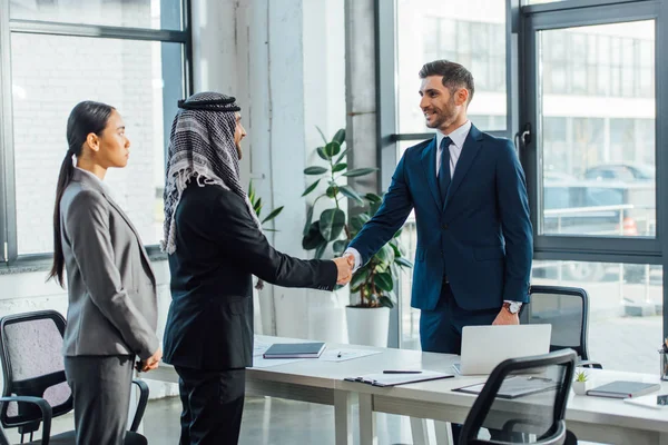 Professional multiethnic businesspeople shaking hands on meeting with translator in office — Stock Photo