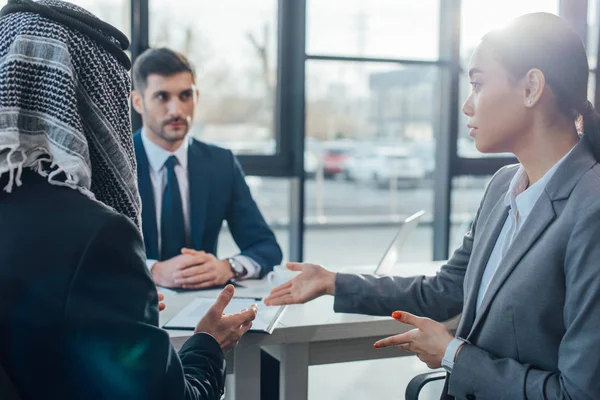 Multicultural business partners talking on meeting with translator in office — Stock Photo