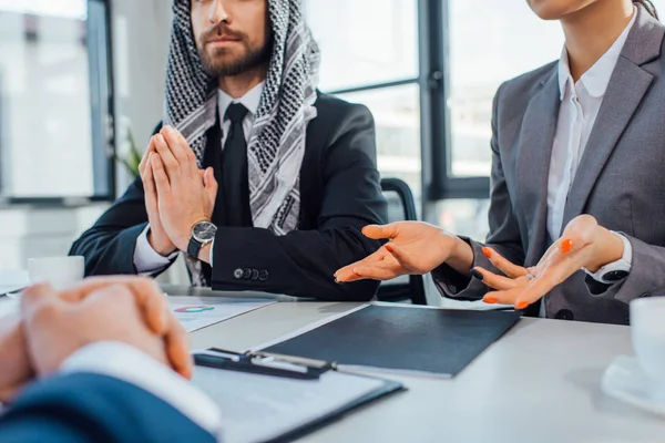 Vista ritagliata di partner commerciali multiculturali che parlano di incontro con il traduttore in ufficio — Foto stock