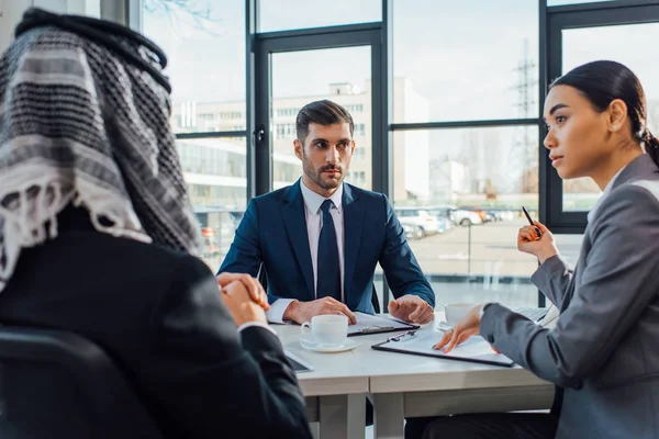 Multicultural business partners talking on meeting with translator in office — Stock Photo