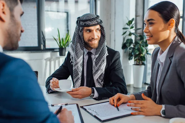 Happy multiethnic business partners on meeting with translator in office — Stock Photo