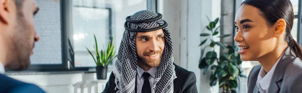 Panoramic shot of happy multiethnic business partners on meeting with translator in office — Stock Photo